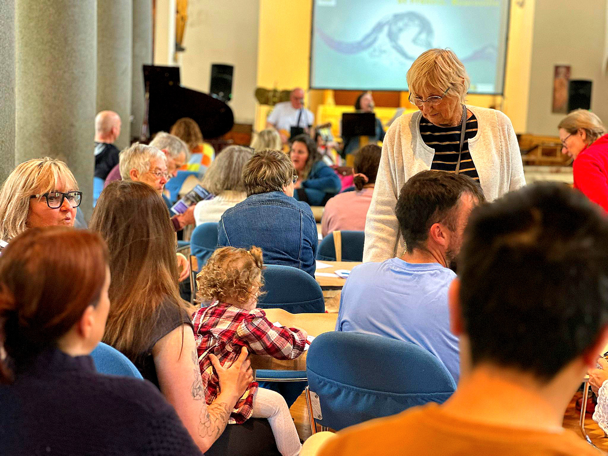 A church full of people sit together talking